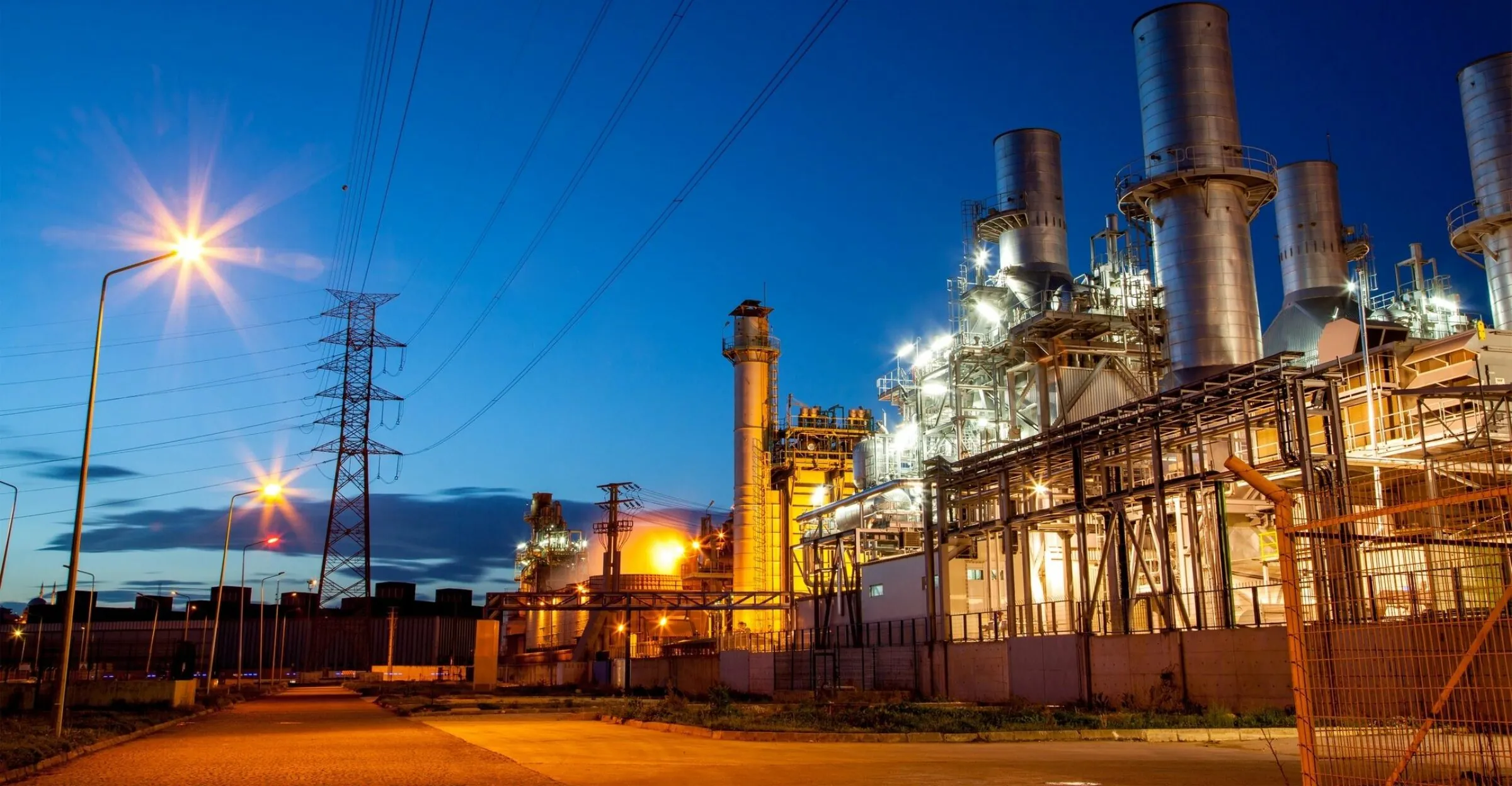 Industrial power generation facility at dusk with gas turbine systems